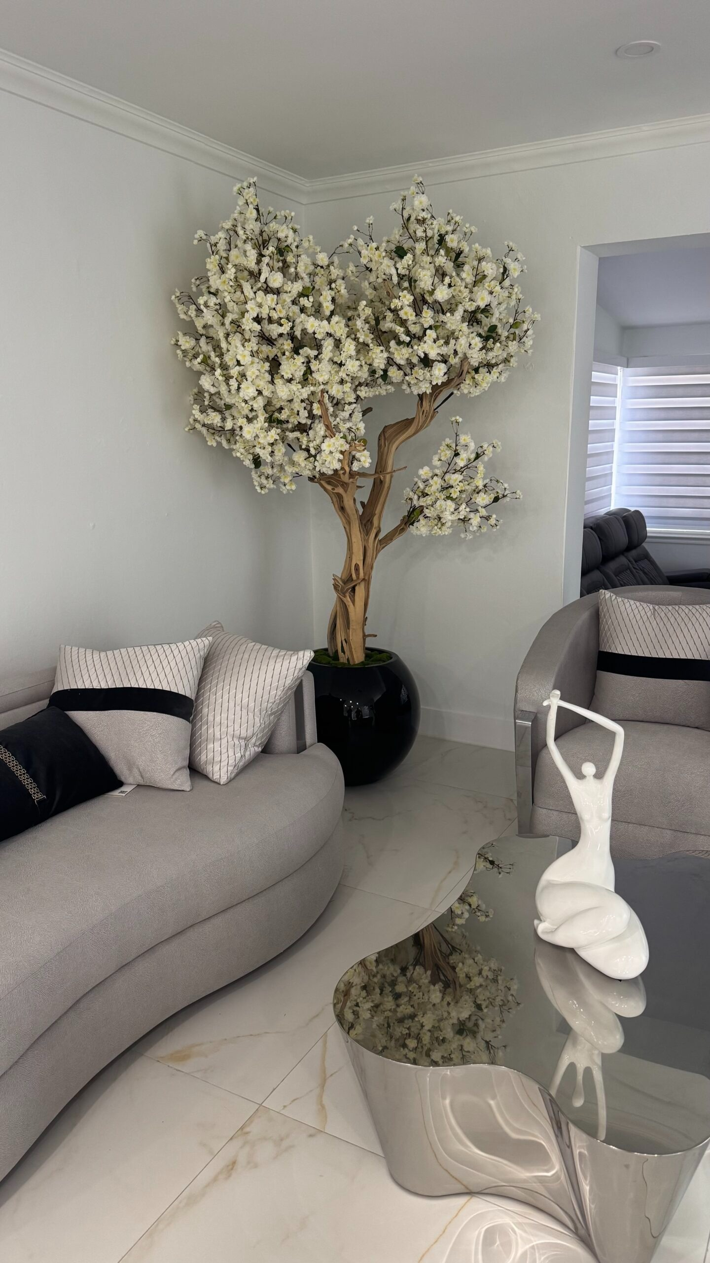 Weißer Kirschblütenbaum in einer schwarzen runden Vase