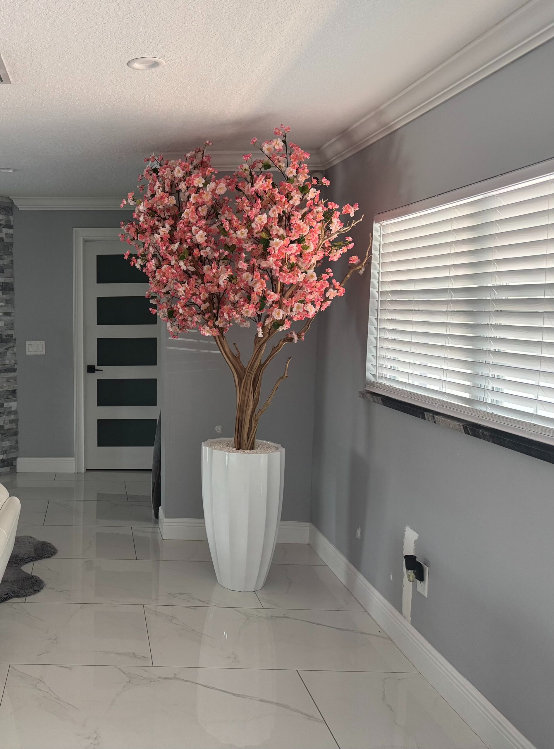 Rosa Kirschblütenbaum in einer weißen abgeschrägten Vase