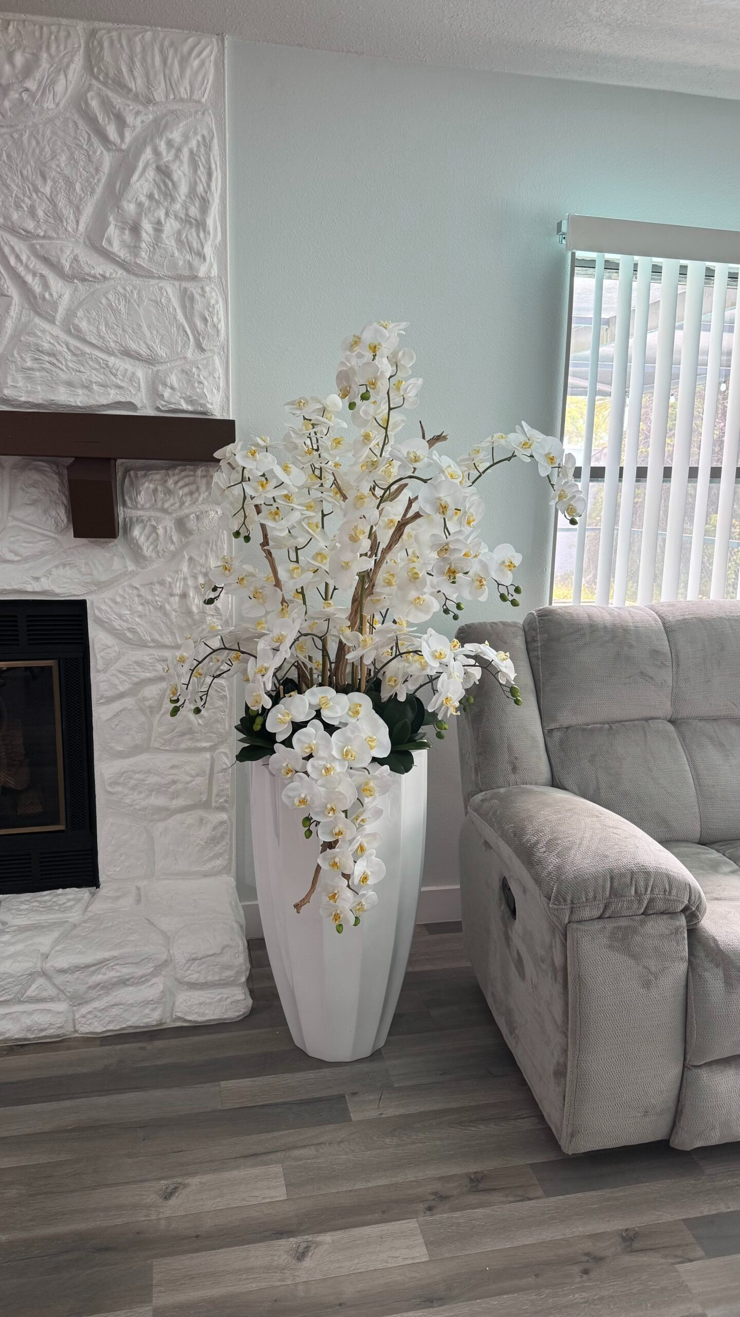 Kaskadierende weiße Orchideen in einer weißen Vase